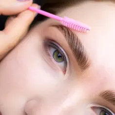 Stylist układa brwi szczoteczką. Zastanawiasz się, ile kosztuje laminacja brwi? Efekt jest zachwycający!